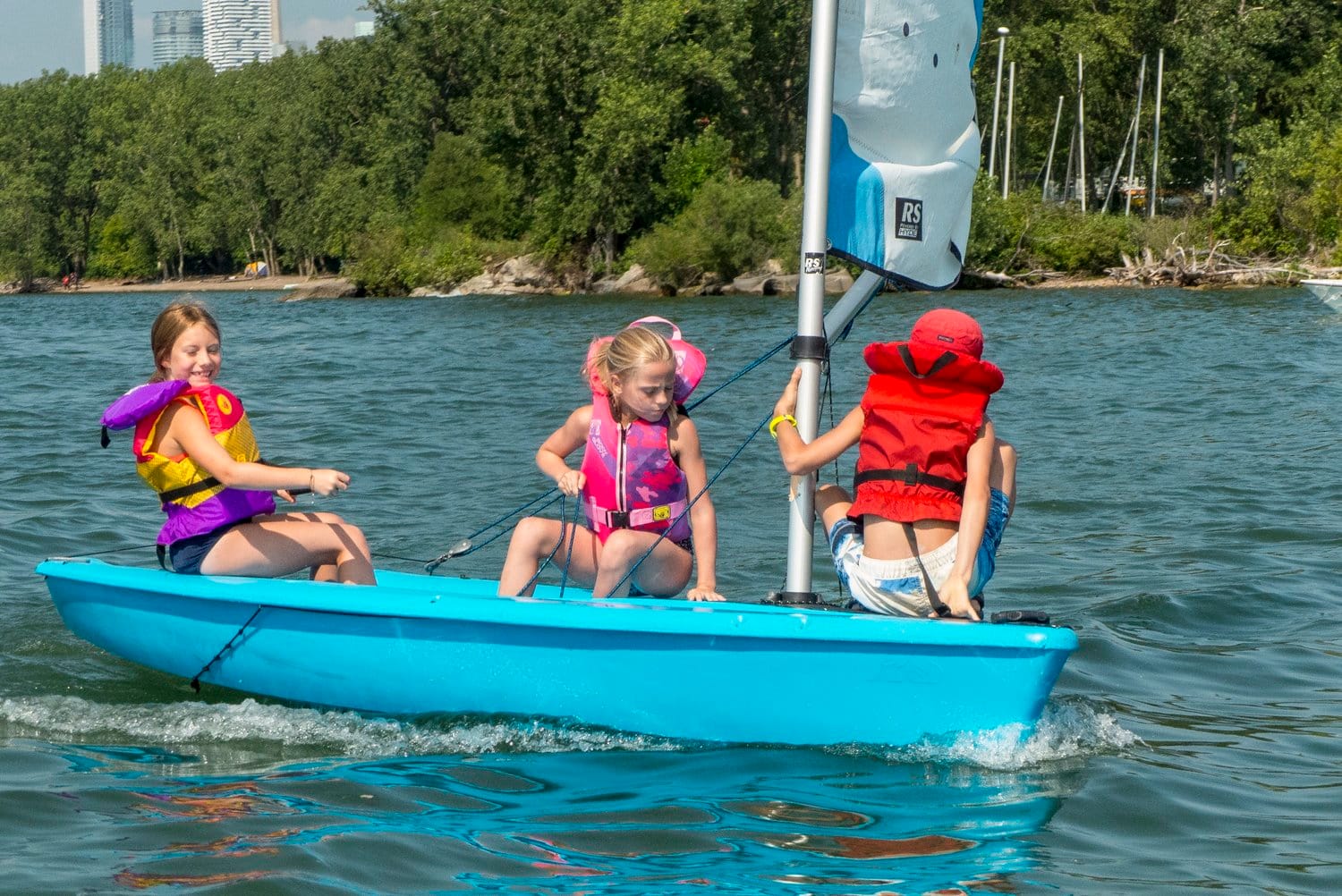 Three girls on blue sailboat