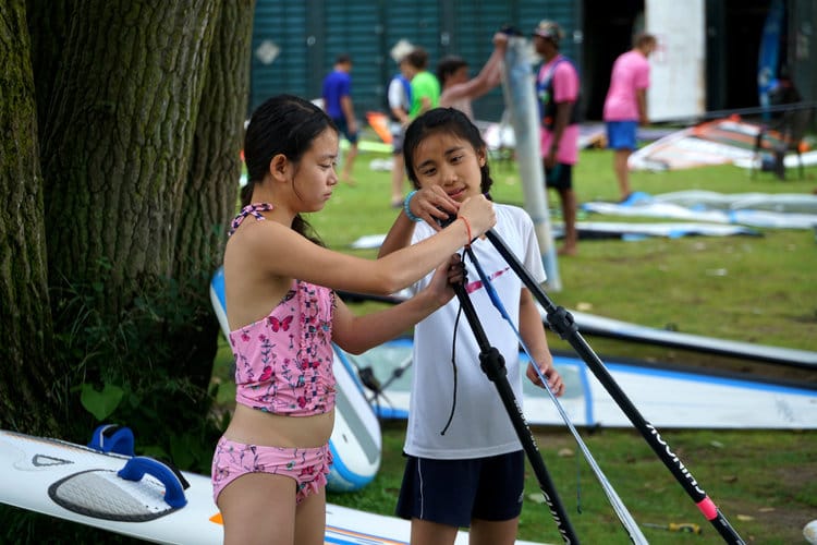 Kids setting up windsurfing wishbone