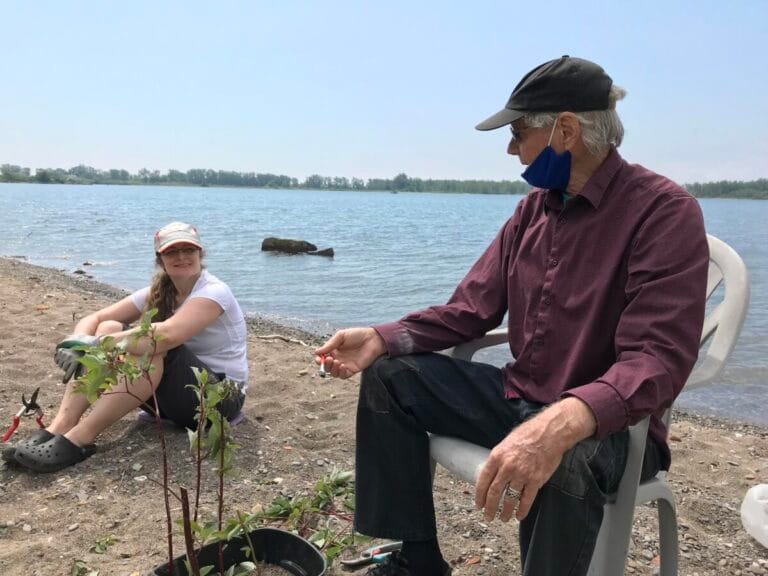 Two people sitting by the water